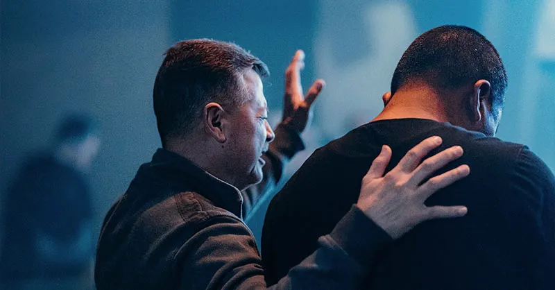 Men praying with each other
