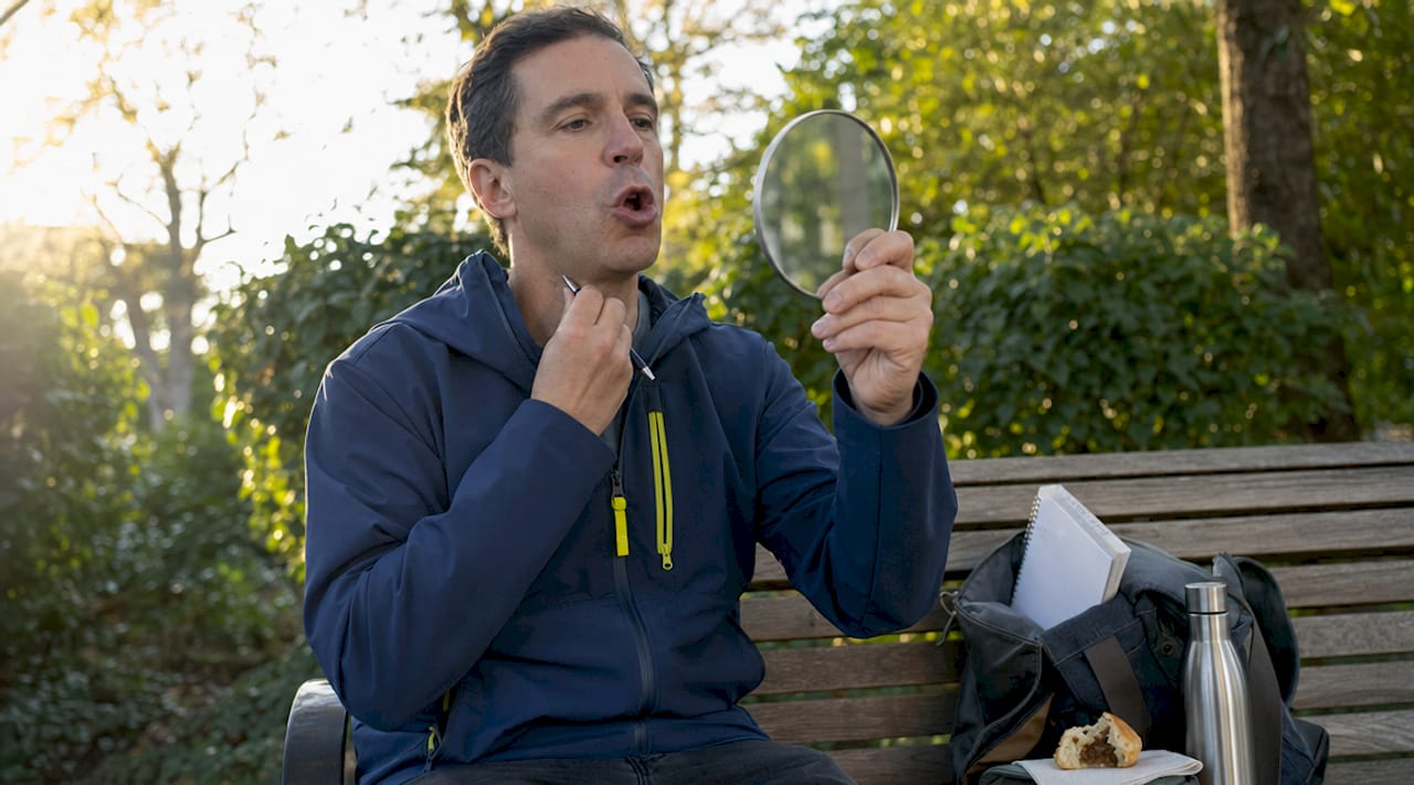 Man practicing French R sound with mirror