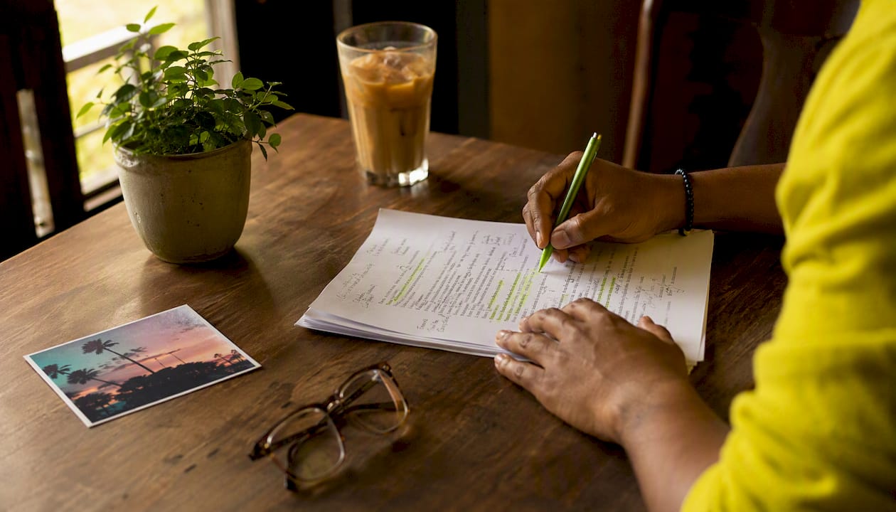 Hands annotating printed song lyrics