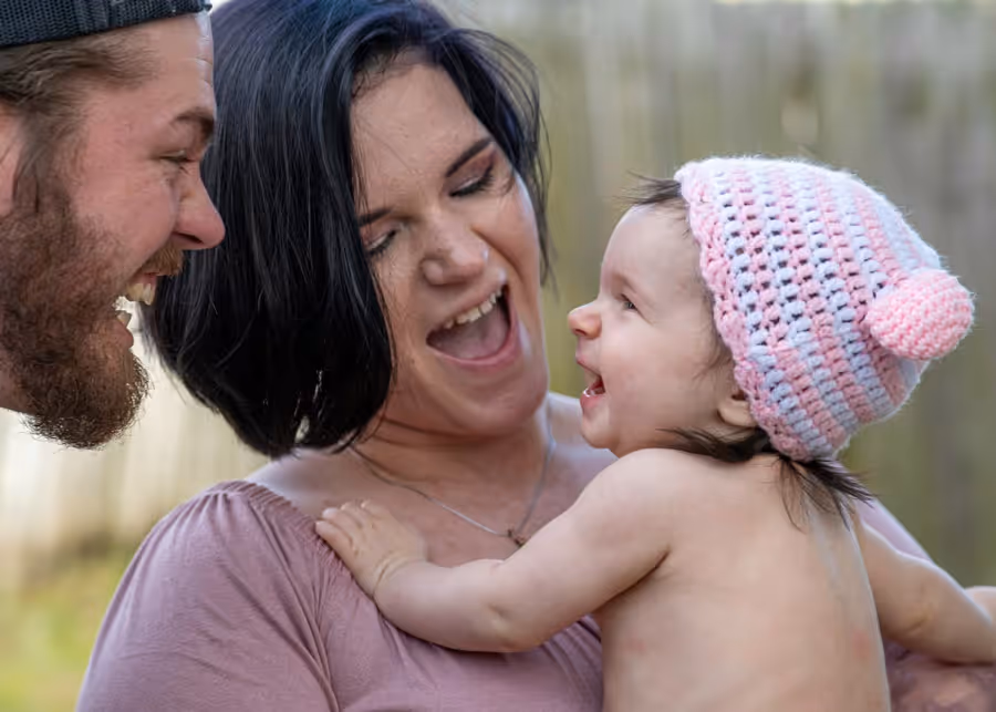 A man and a woman holding a baby in their arms.