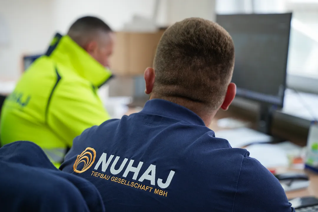 Arbeiter in einer Jacke mit dem Nuhaj-Logo