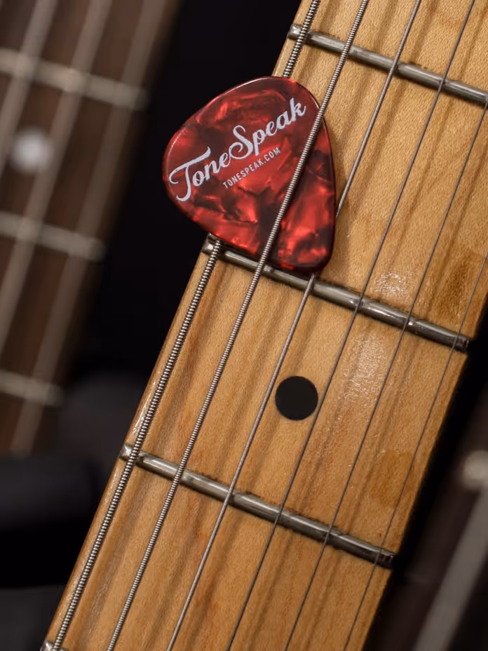 ToneSpeak guitar pick resting on a guitar