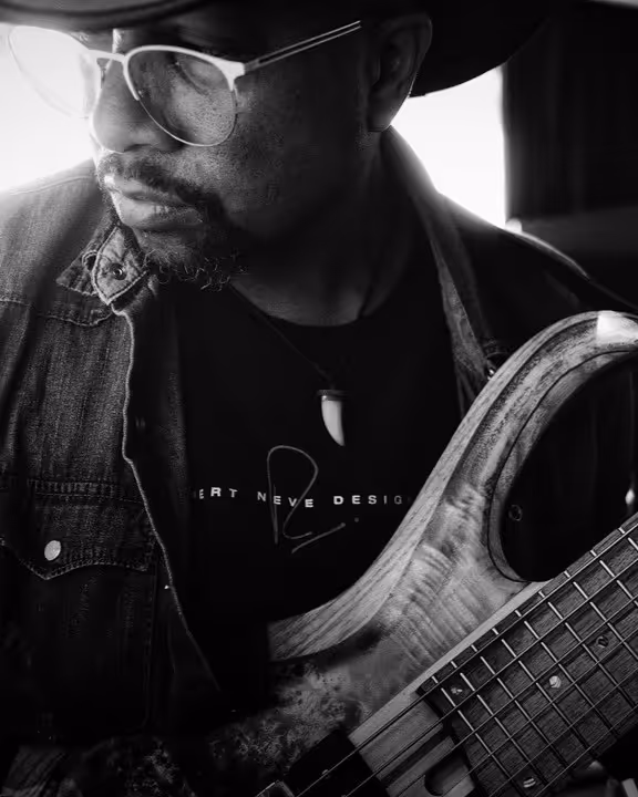 Roland Guerin holding his guitar