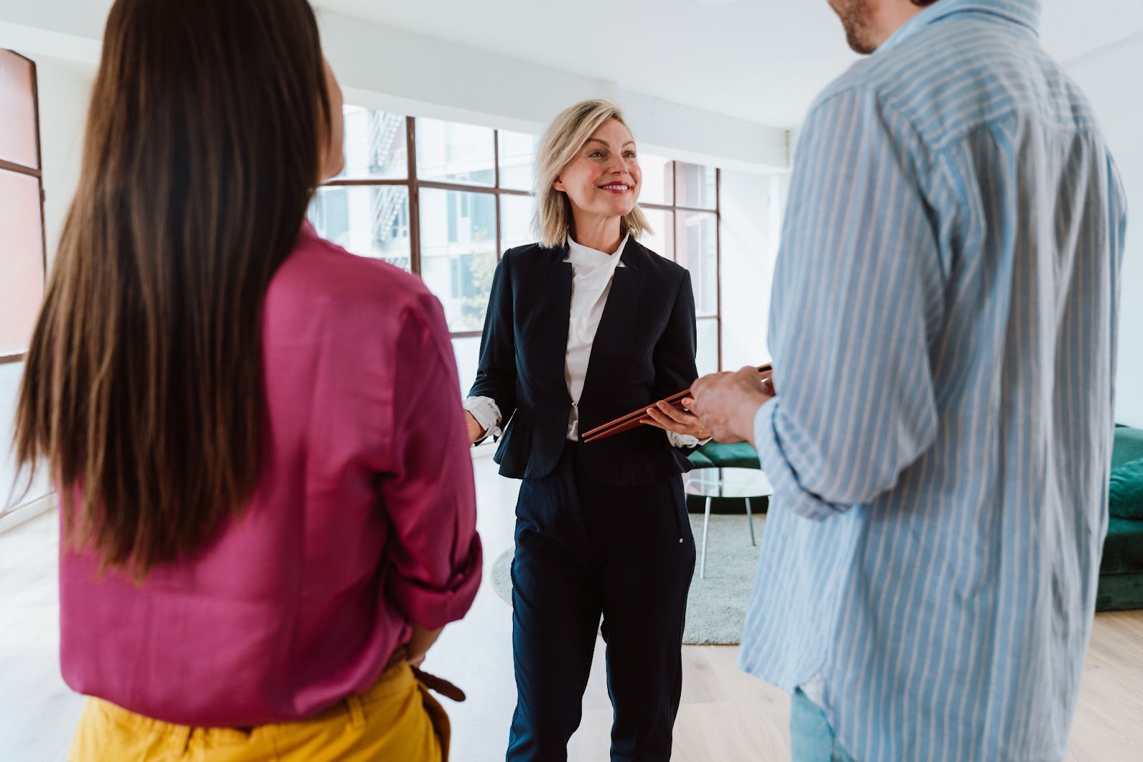 Real estate agent confidently guiding a couple through a property tour, showing strong communication and client-centered focus