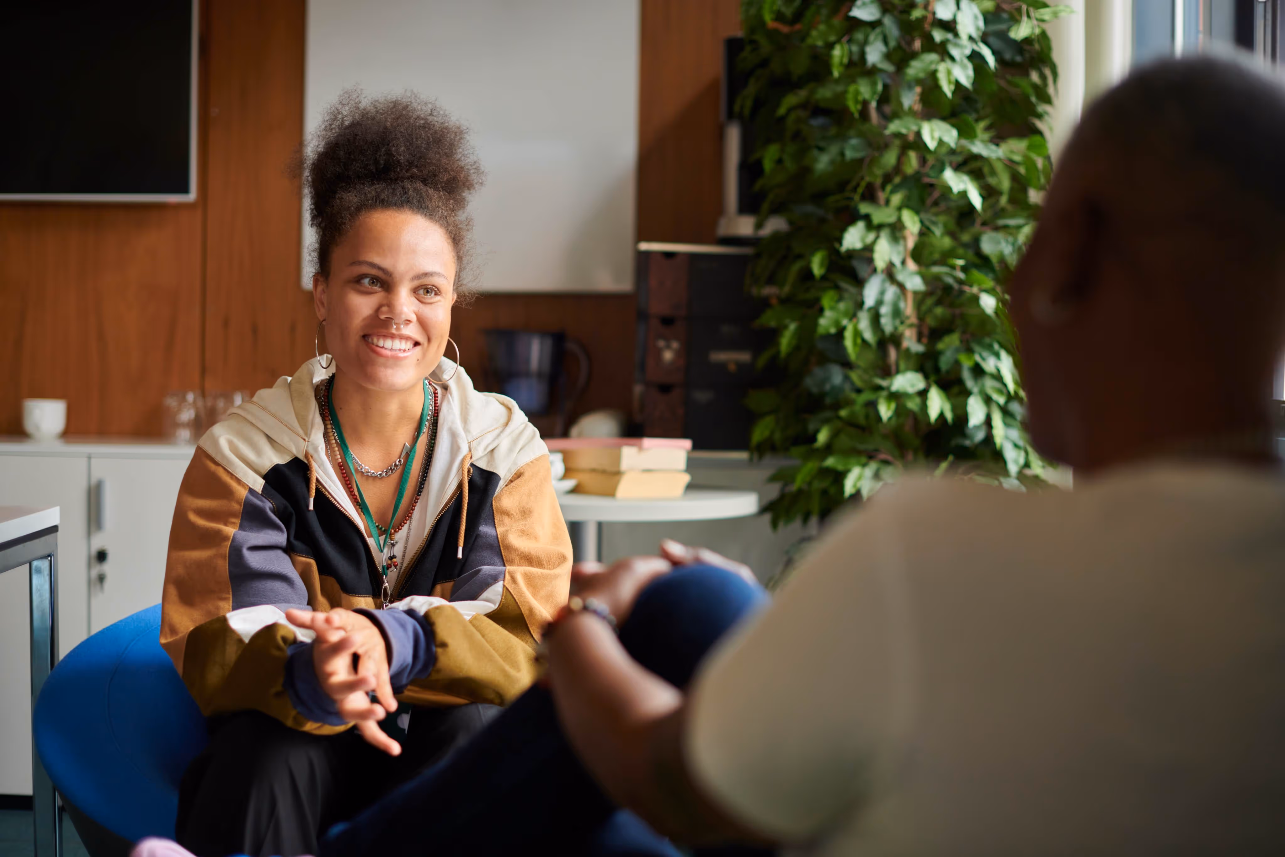 A woman sitting in a chair talking to a man.