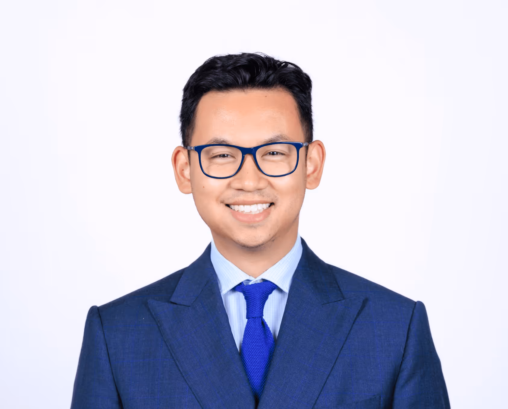 A man wearing glasses and a blue tie.
