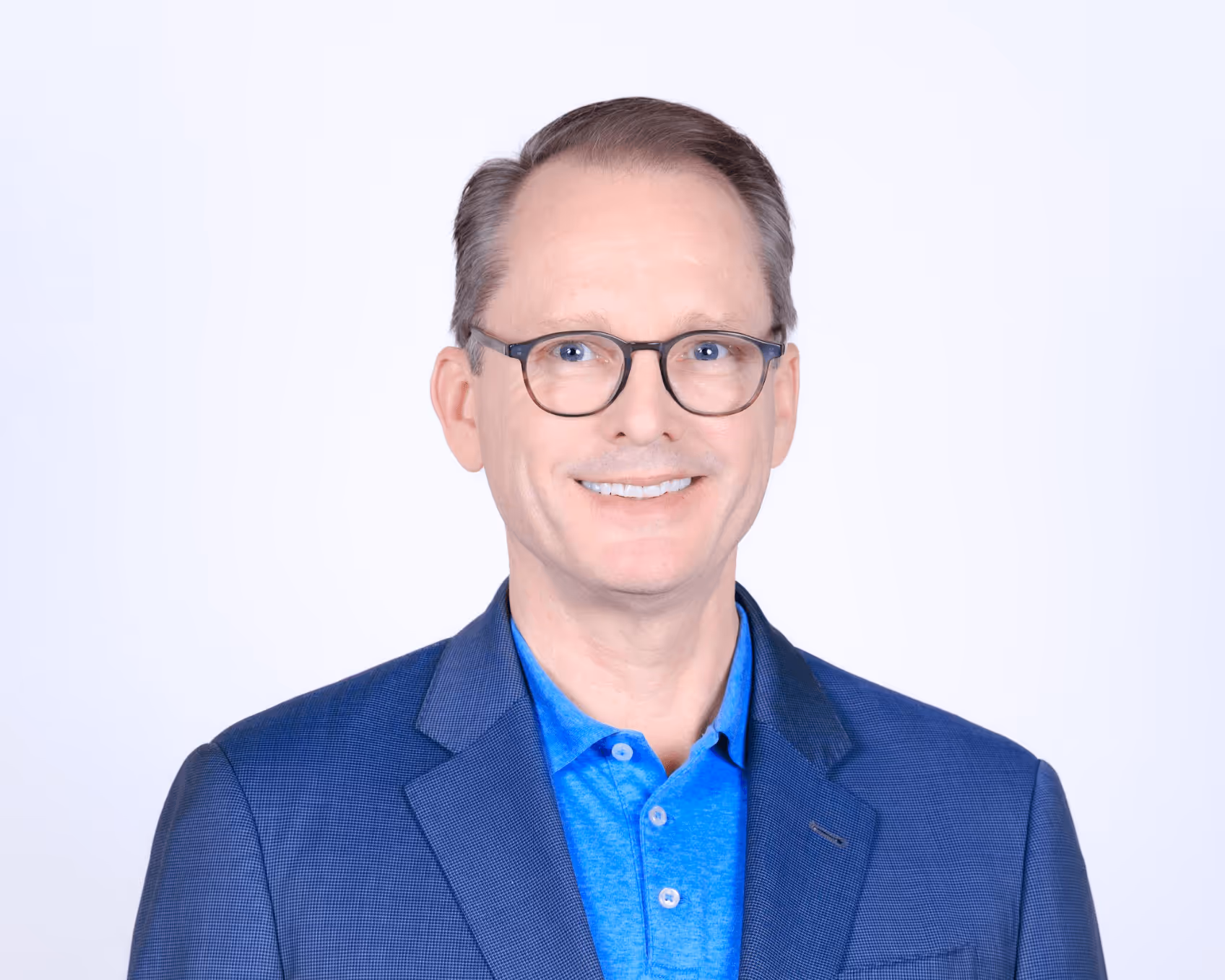 A man wearing glasses and a blue shirt.