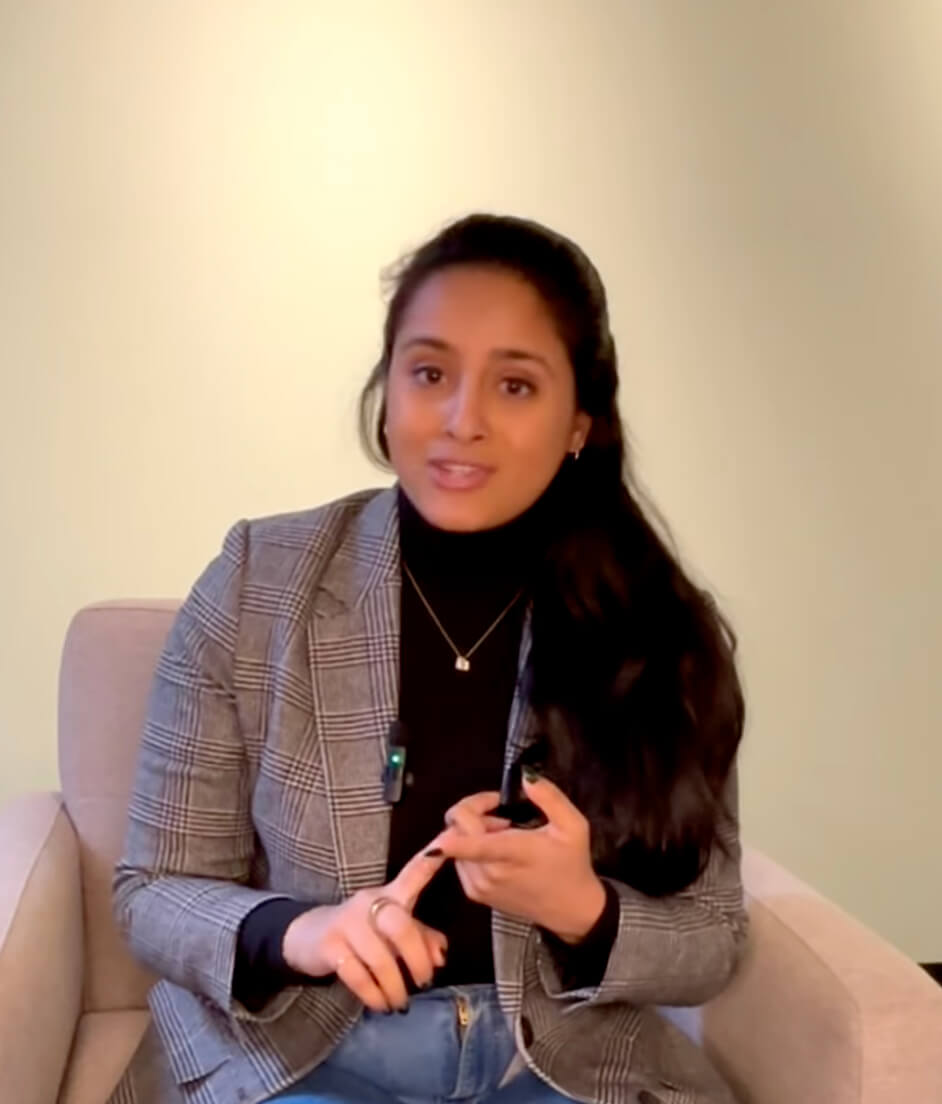 A woman sitting on a couch holding a cell phone.