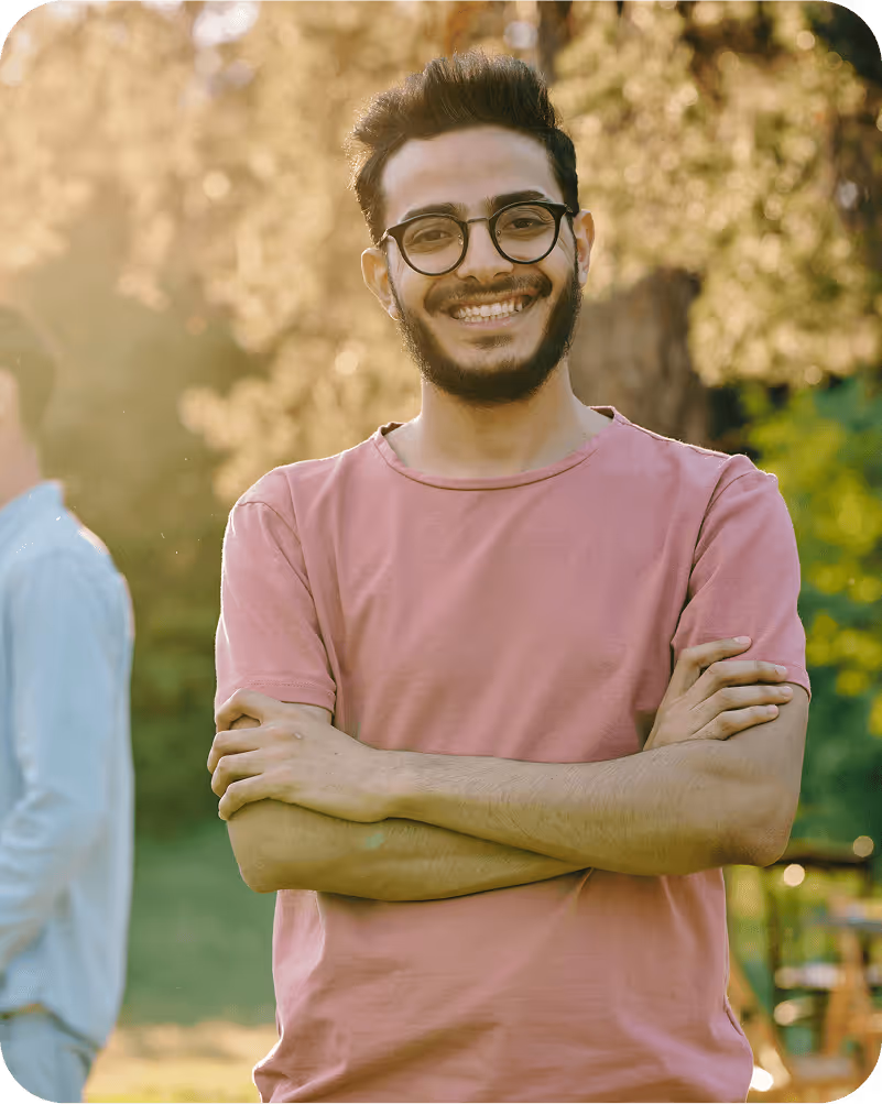 A man with a beard and glasses standing with his arms crossed.