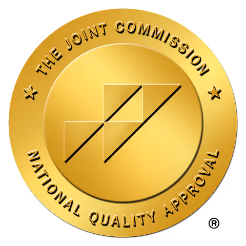 Sello dorado de la Certificación Nacional de Calidad de The Joint Commission con el logotipo geométrico en el centro.