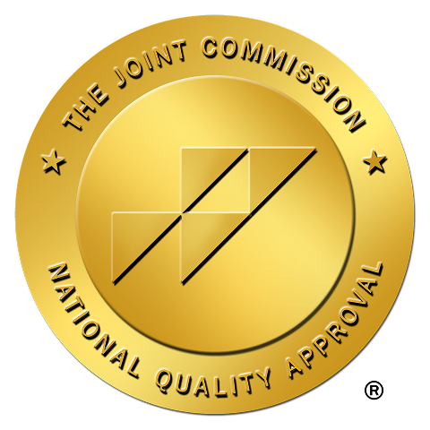 Gold seal of The Joint Commission National Quality Approval with geometric logo in the center.