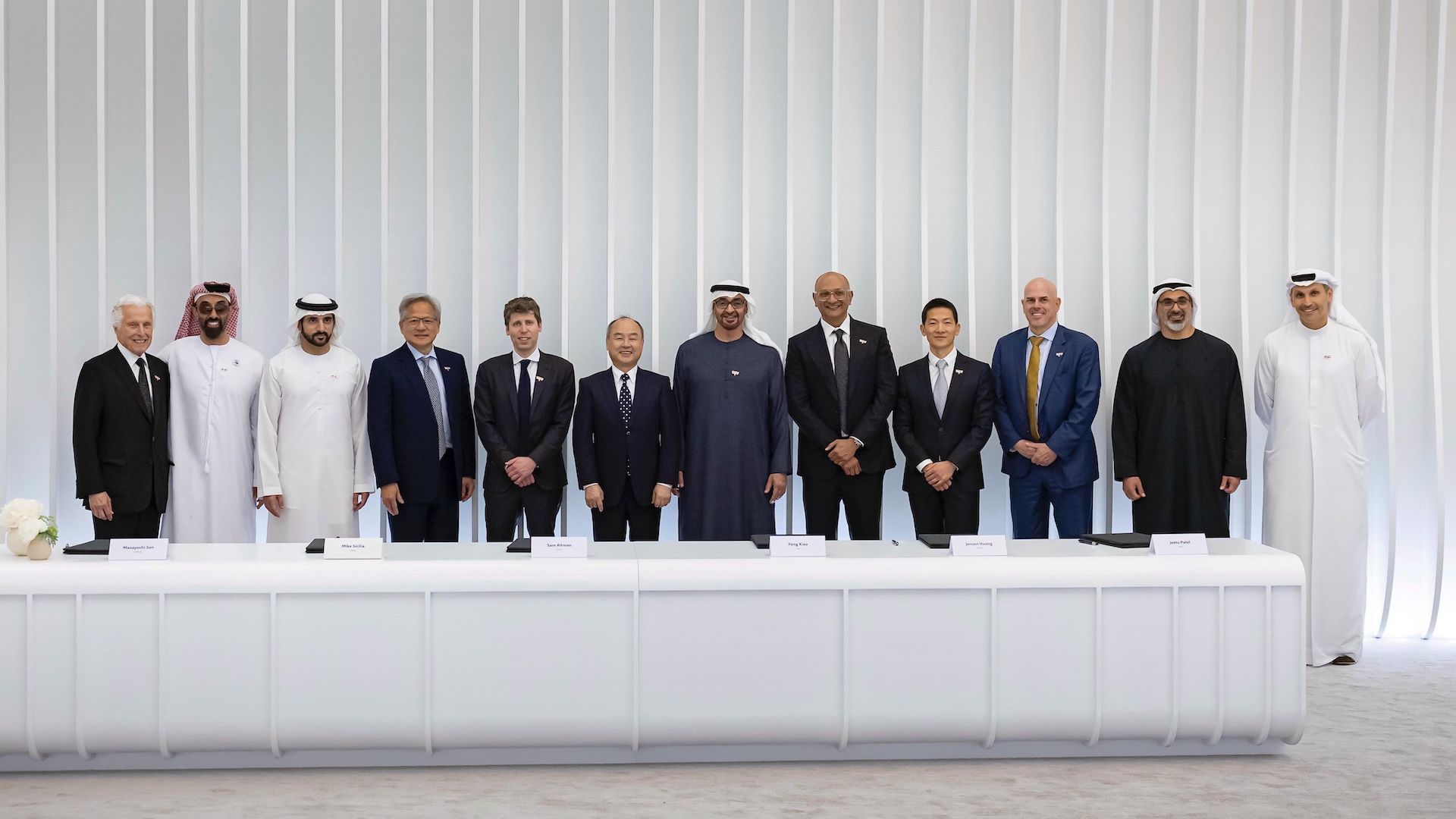 Delegates from the UAE and US gather around a 3D model at the UAE–US AI Cluster, with both national flags displayed in a modern conference setting