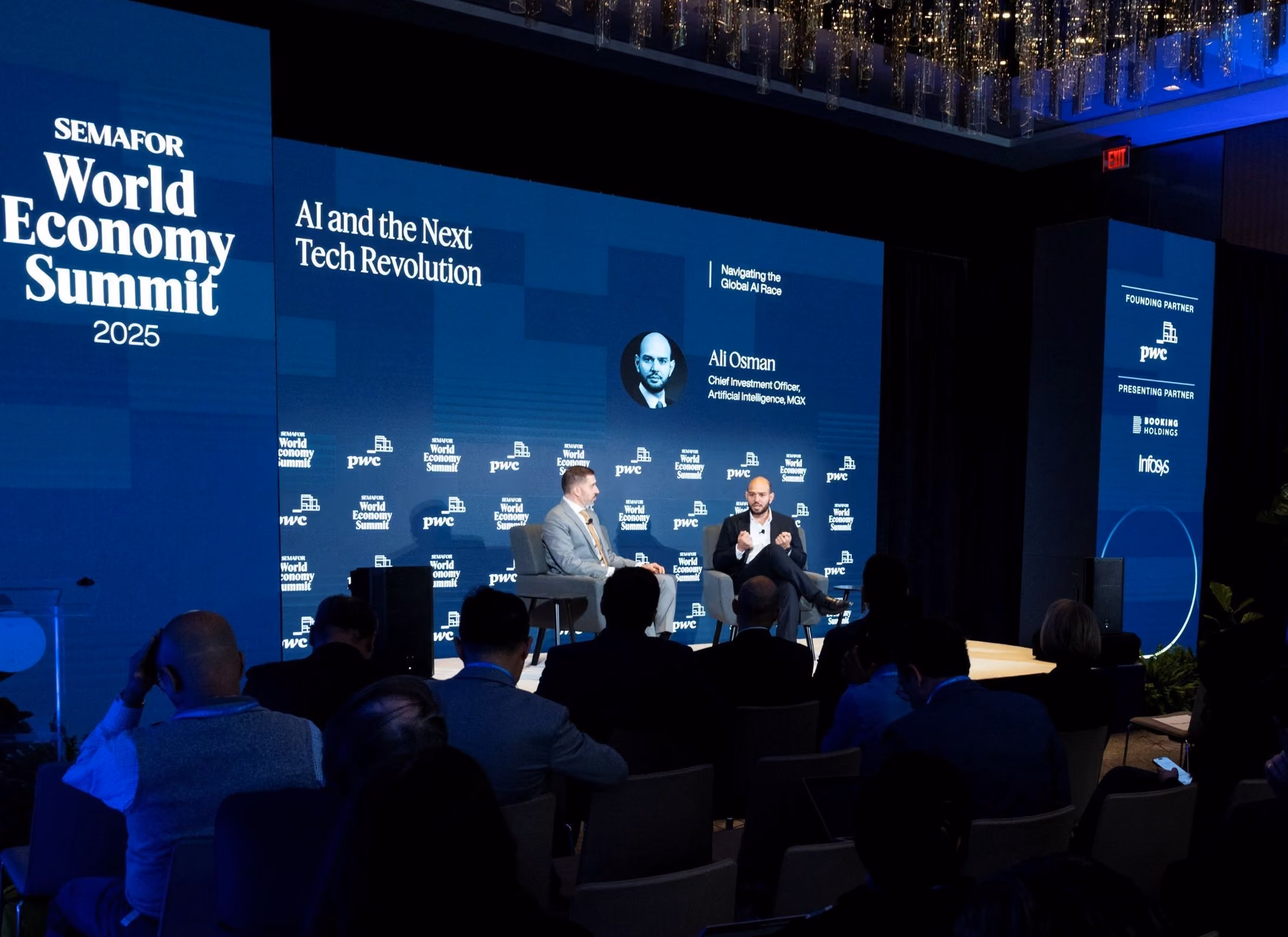 Two men seated on stage discussing AI and tech at Semafor World Economy Summit 2025 with audience watching.