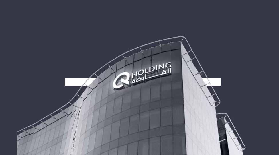 Modern curved glass building with illuminated Q Holding logo and Arabic text on upper facade.