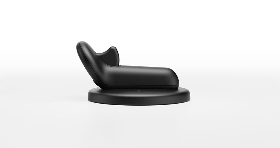 Side view of the Marc Newson Flite Controller resting on its round charging dock.