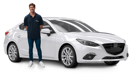Smiling person in blue outfit standing next to a white Mazda sedan