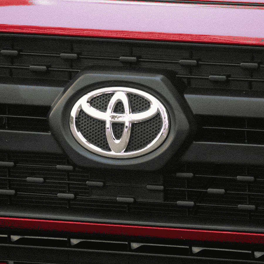Toyota logo on black and red vehicle grille close-up