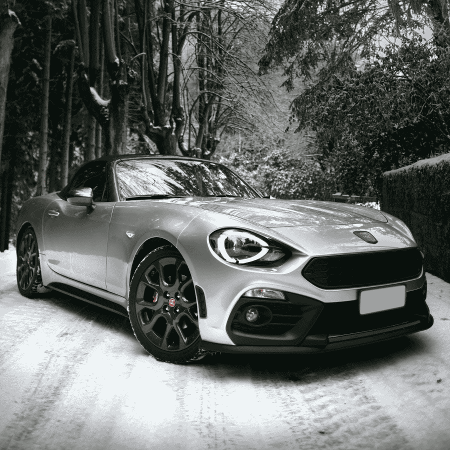 Pickup truck pulling a livestock trailer across a grassy rural field