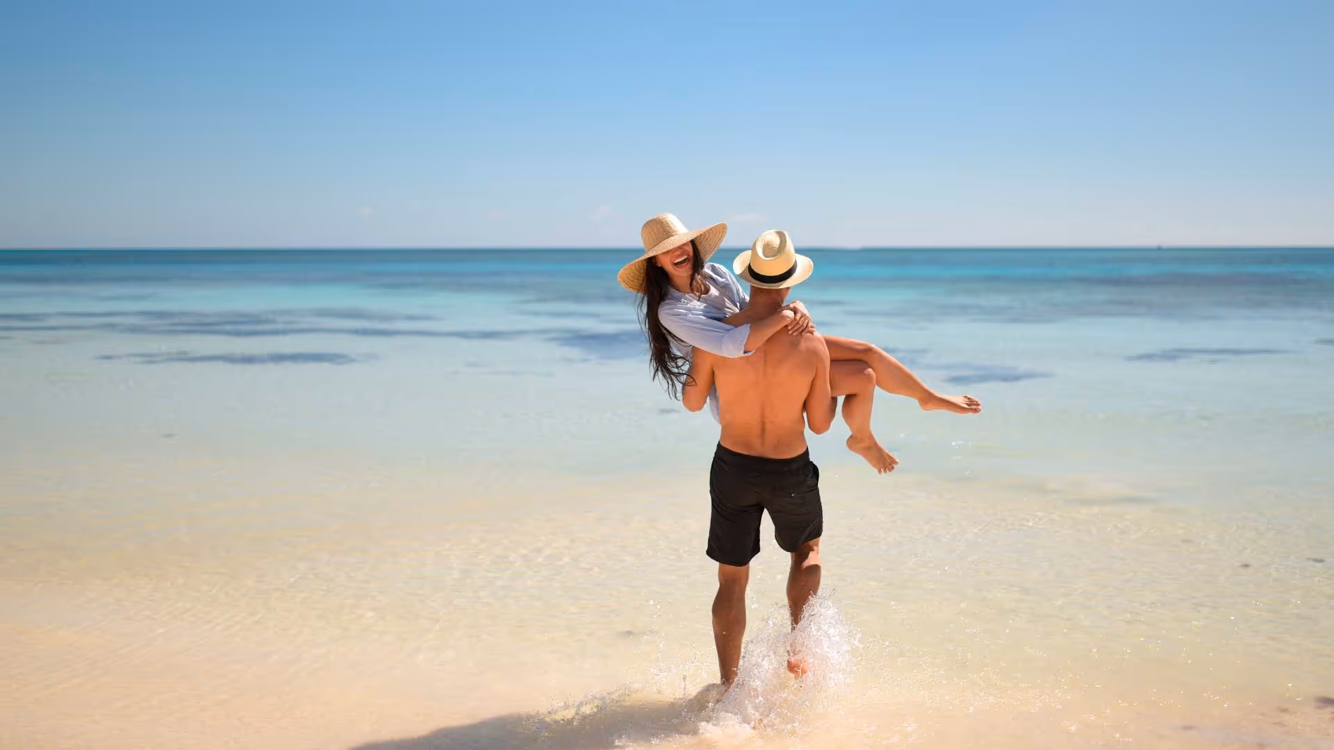 a man carrying a woman on his back on a beach