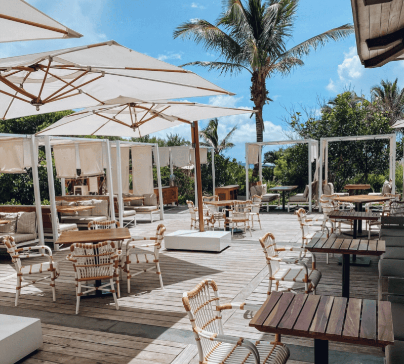 a patio with tables and chairs and umbrellas