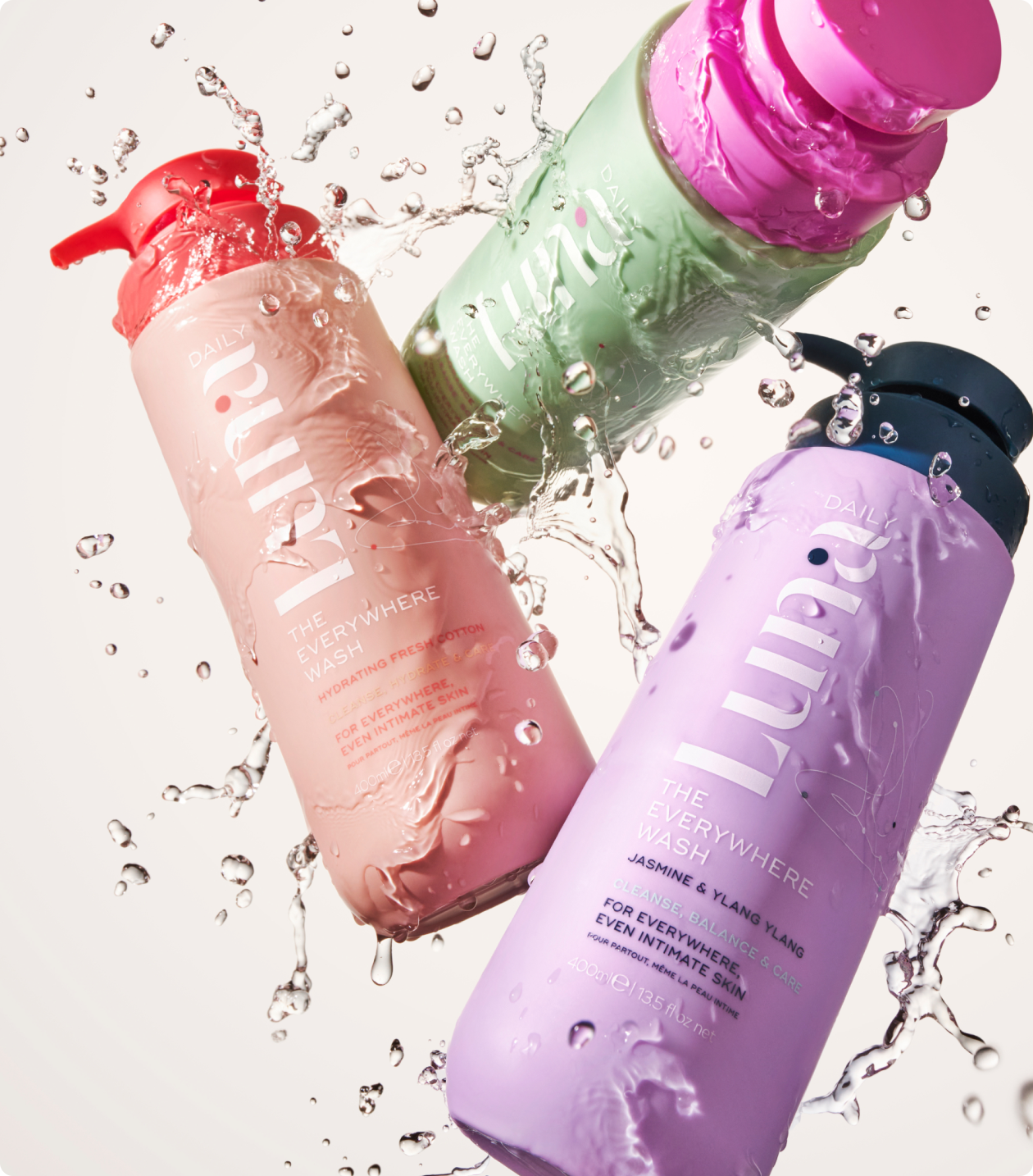Luna Daily body care bottles in pink, green and lilac with a water splash