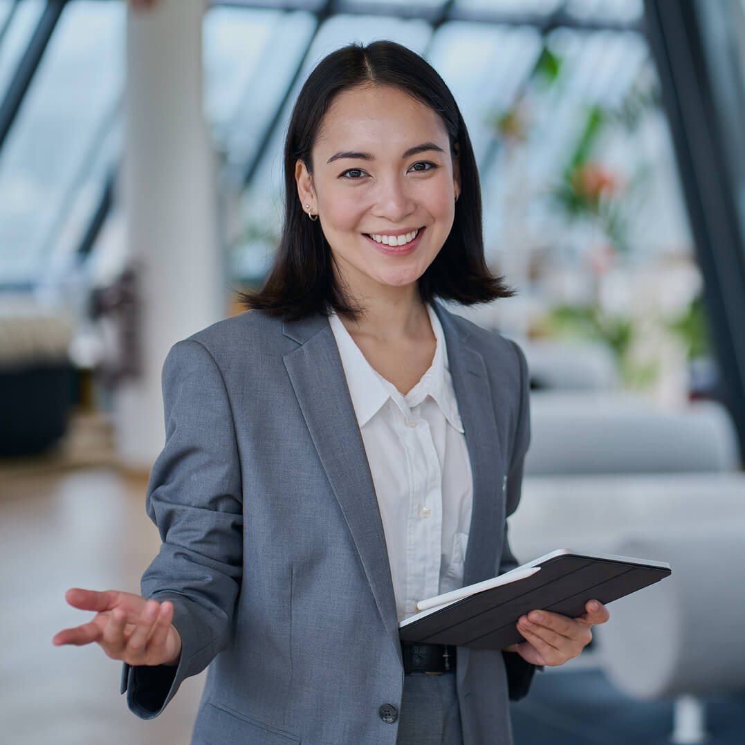 Asian-American female lawyer standing with tablet in her hand.