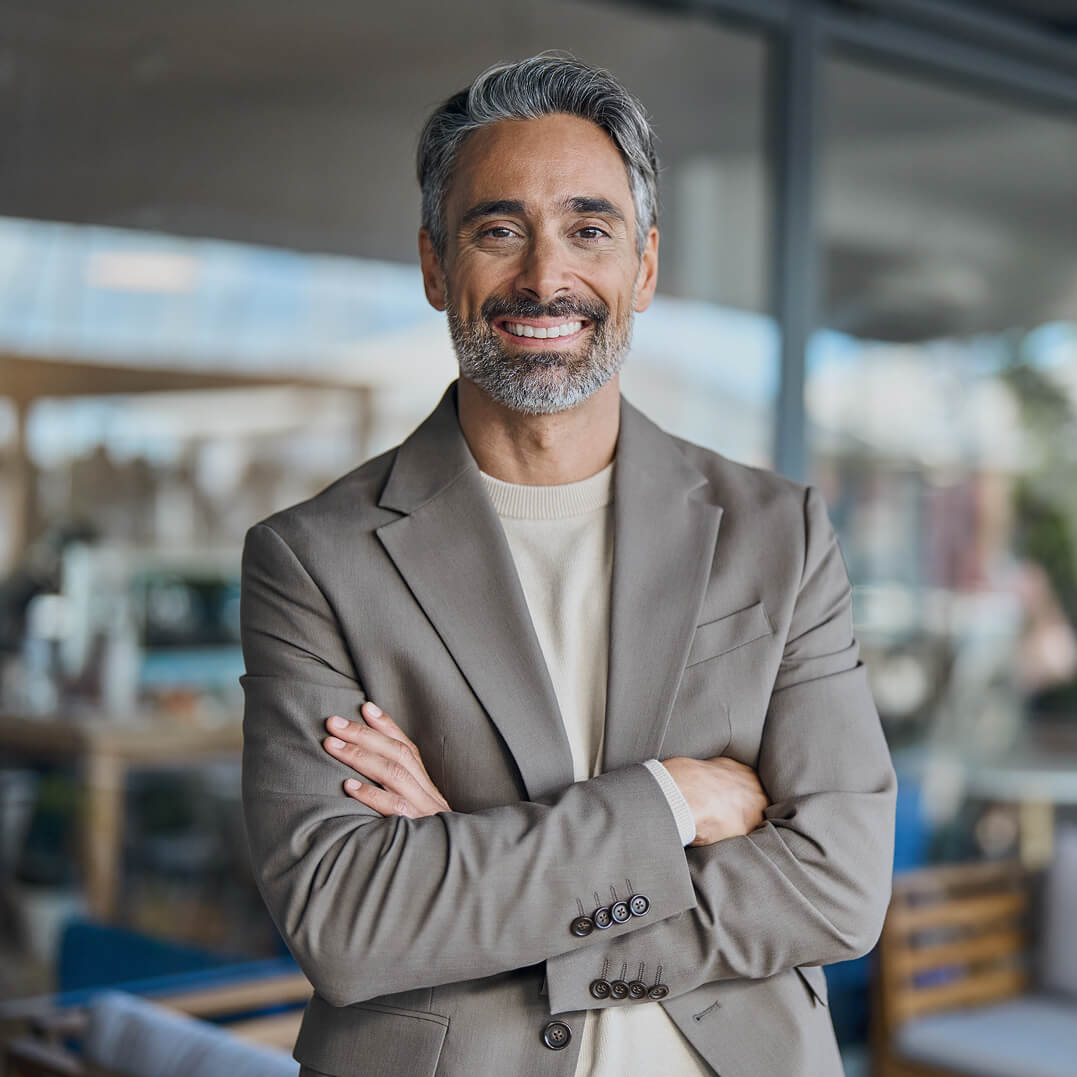 Male lawyer standing with arms folded over his chest .