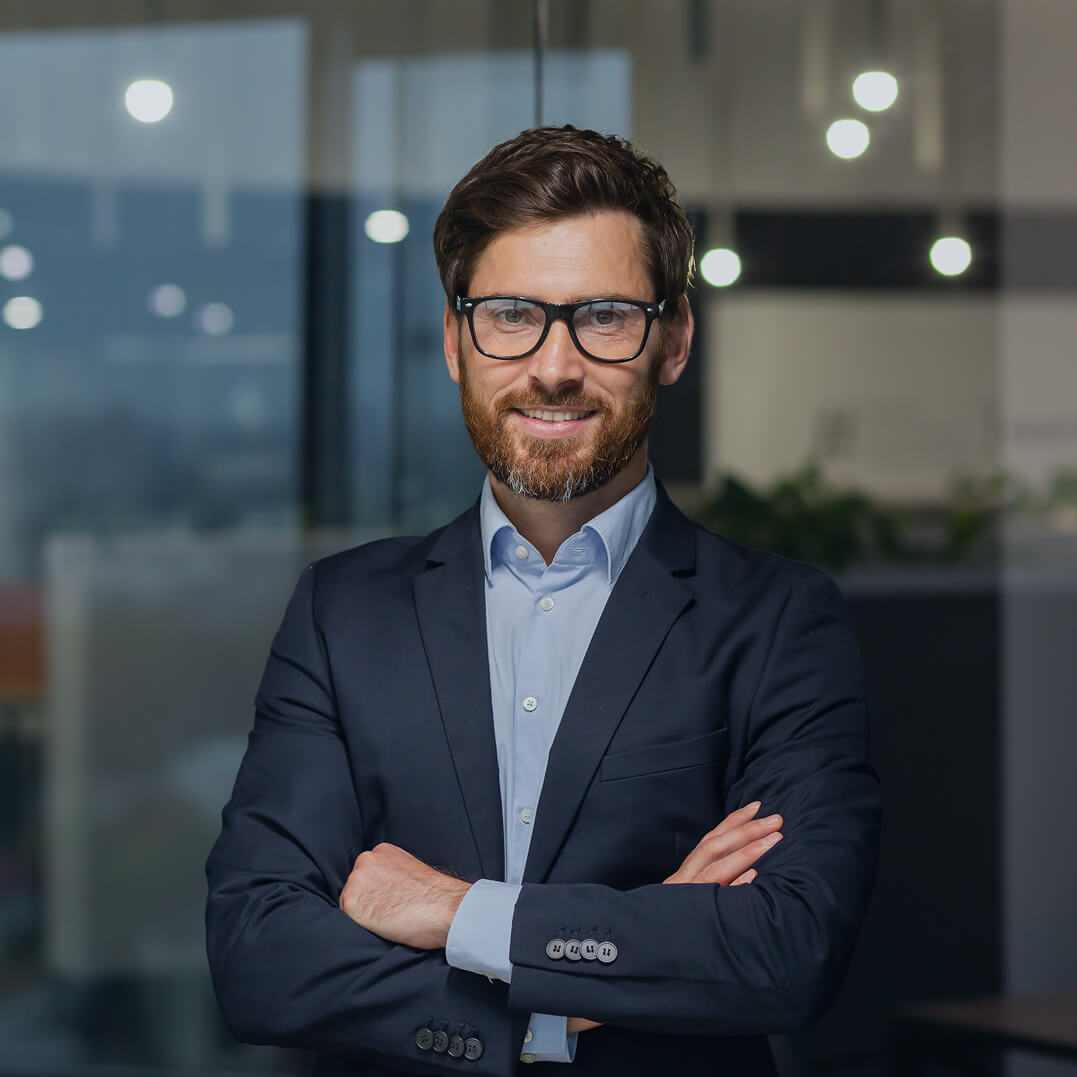 Male lawyer standing with arms folded over his chest .