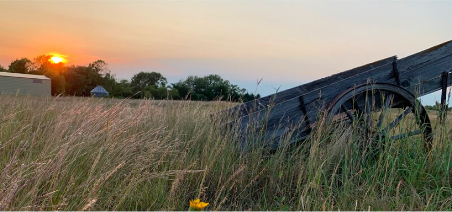 Prairie sunset with an old wagon in the foreground