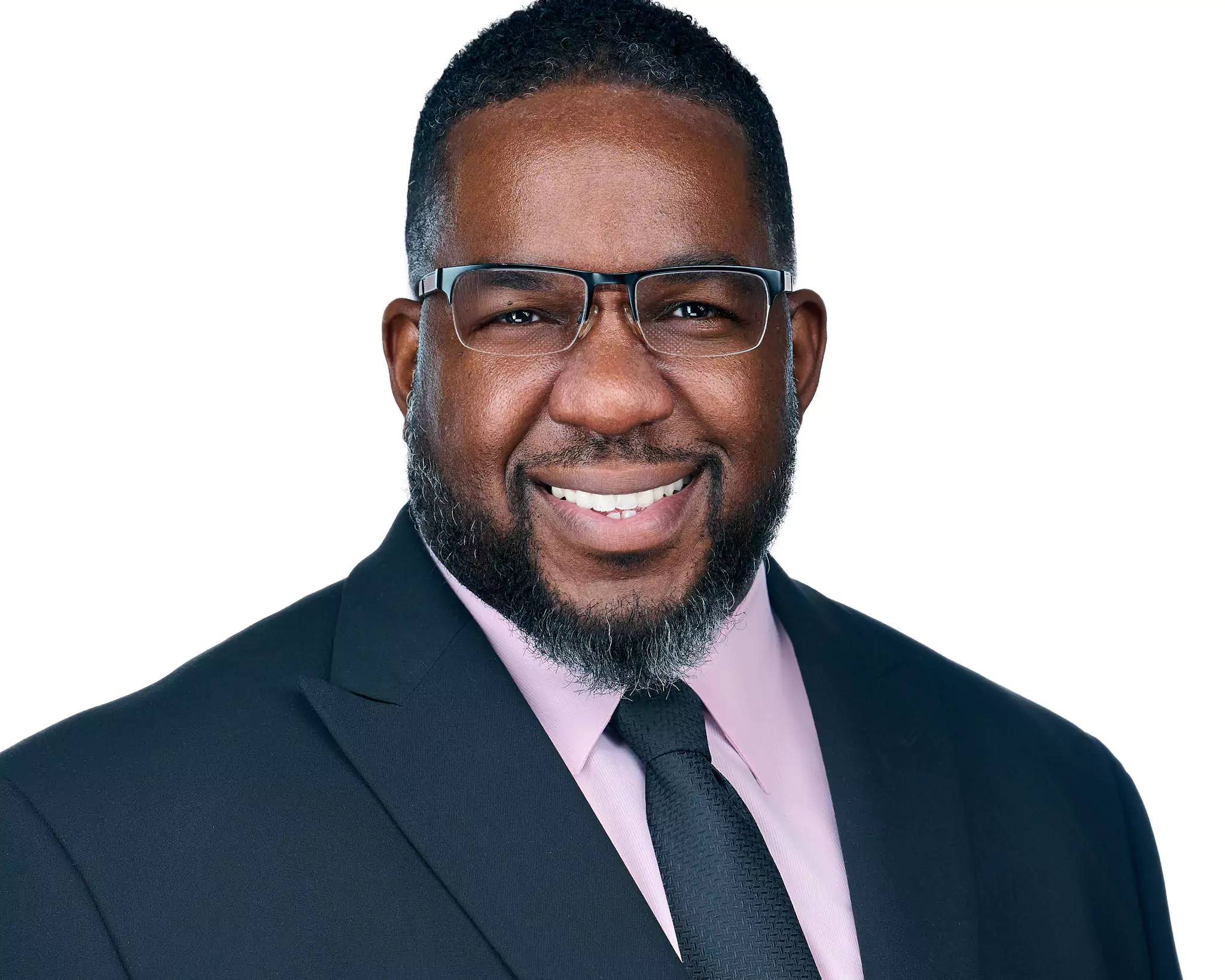 A man wearing a suit and tie smiles for the camera.
