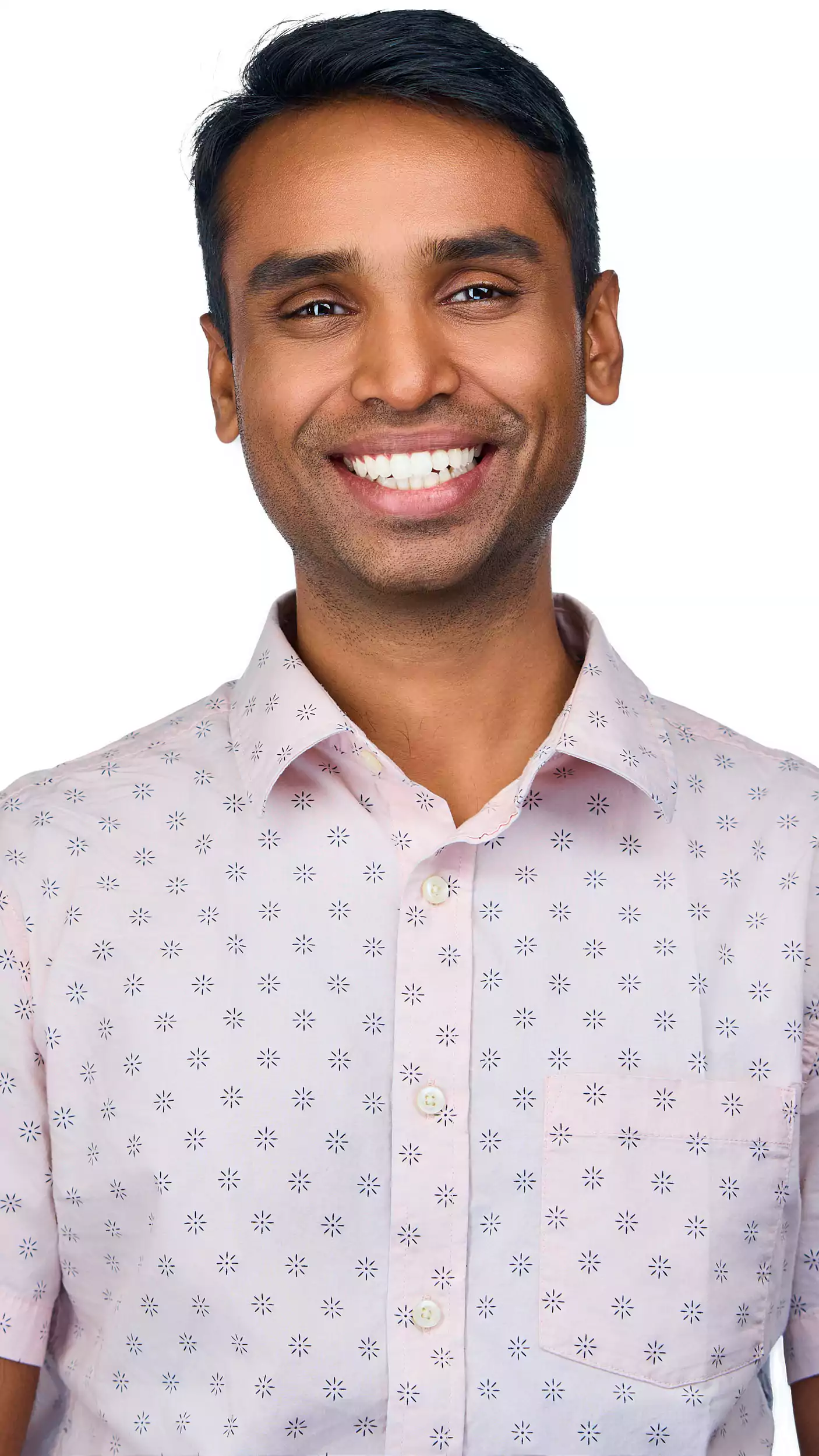 A man with a pink shirt and a smile on his face.