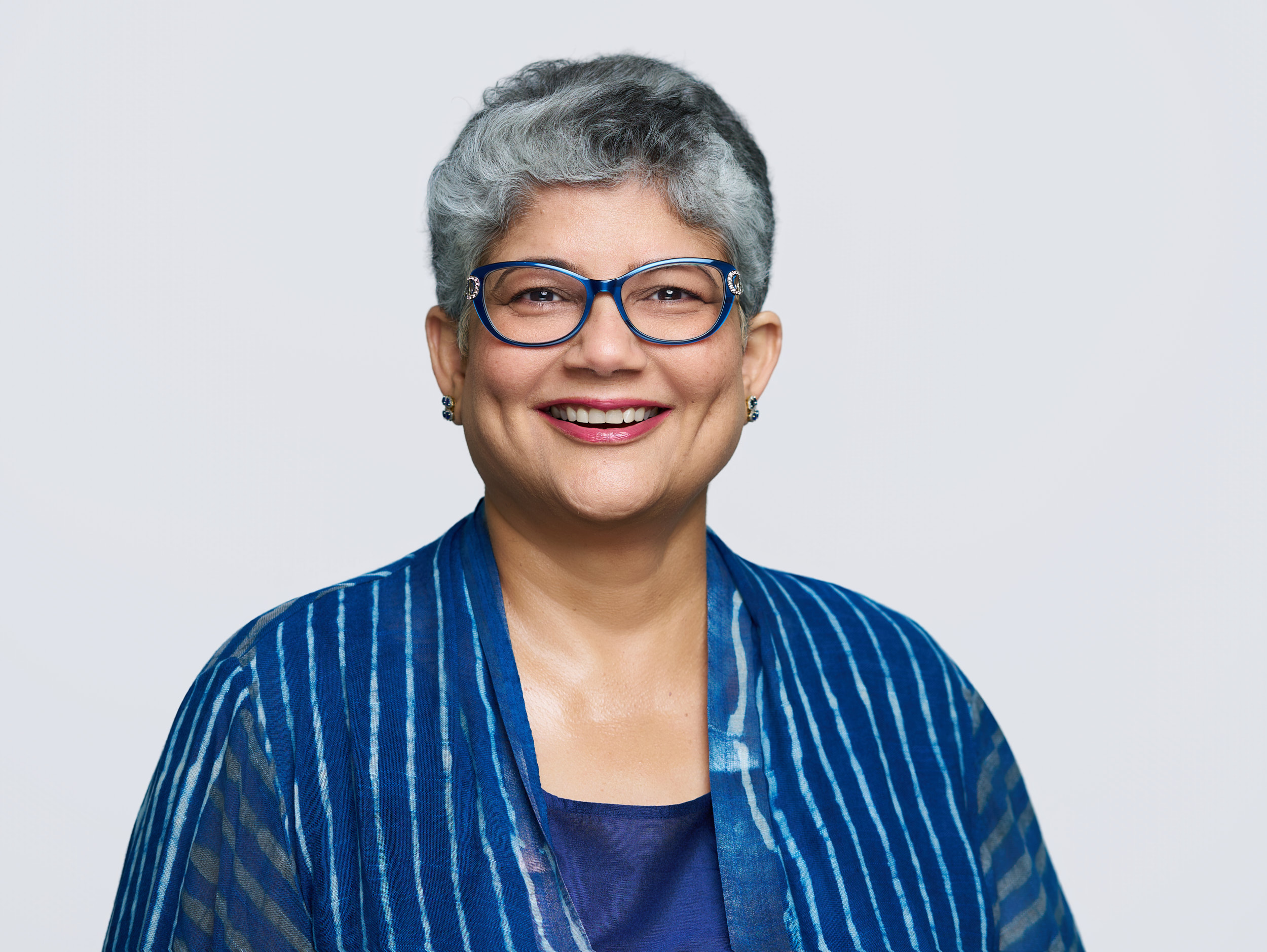 Business portrait of smiling woman with short gray hair and glasses for Freddie Mac. Captured during an on-location corporate headshot session.