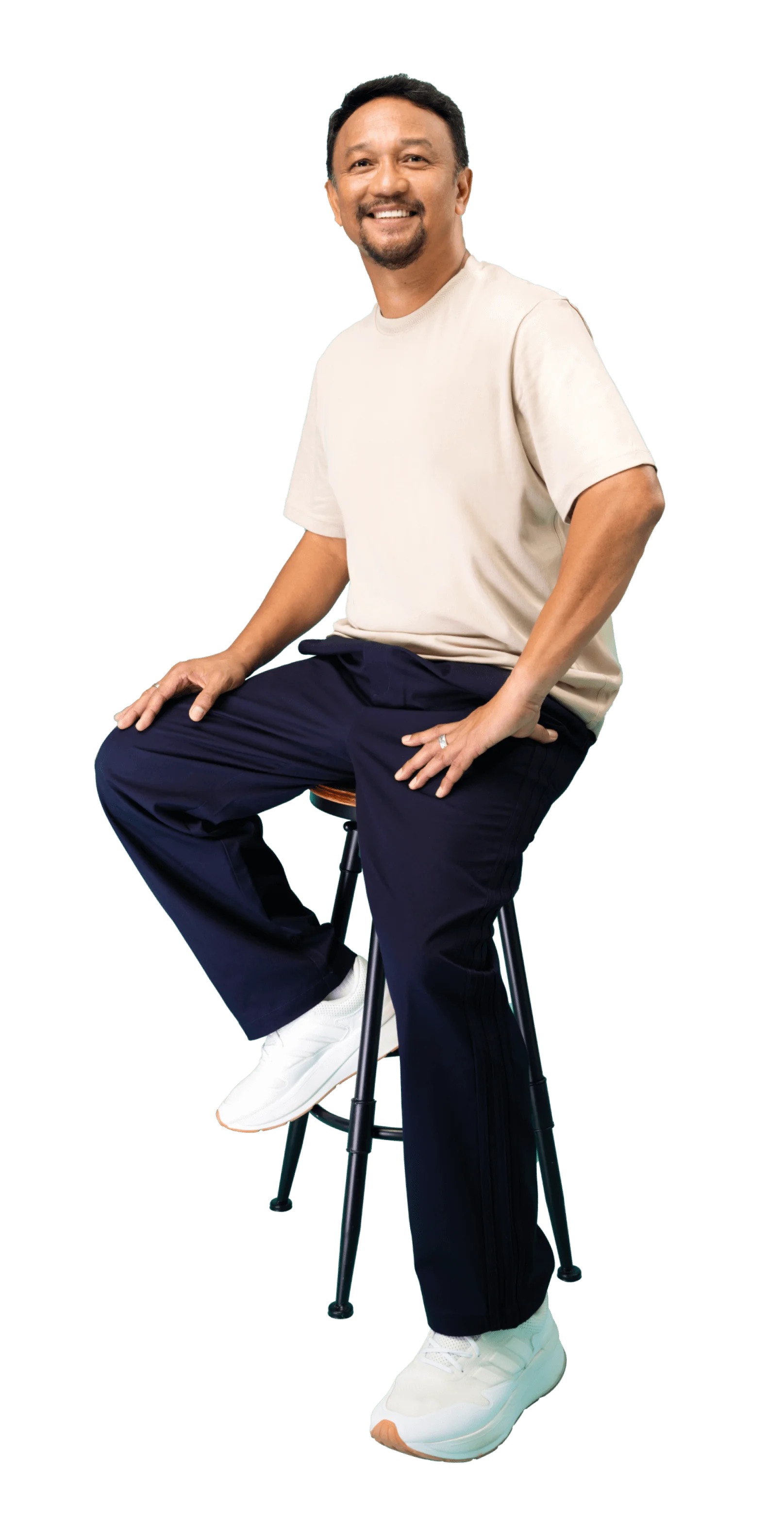 Fandi Ahmed sitting on a stool wearing white shirt and blue jeans