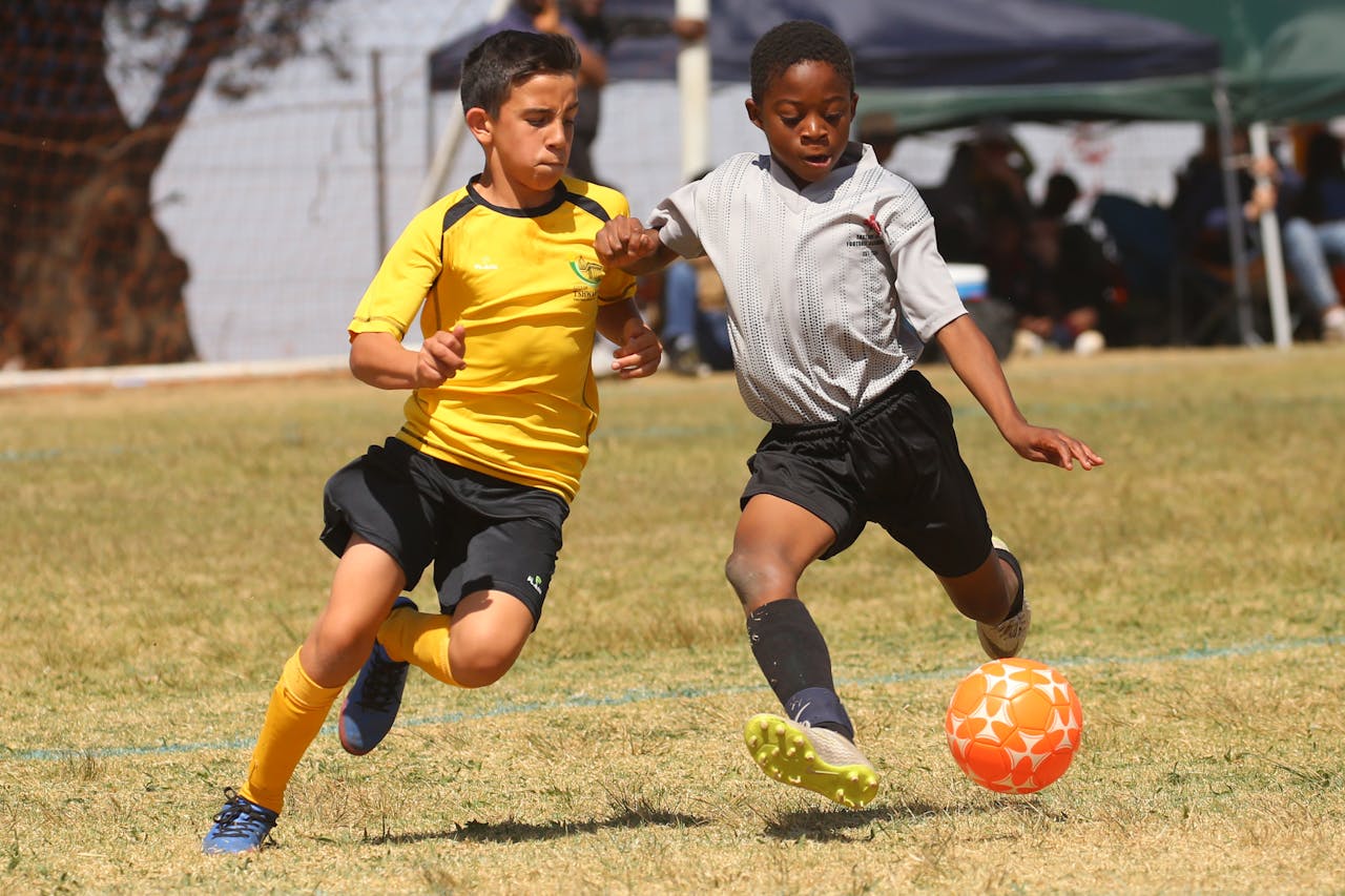 Two young soccer players competing for the ball in a youth match