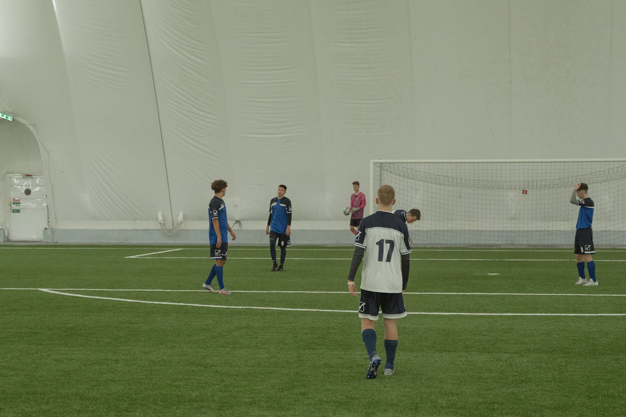 Osner’s FC Junior Academy U9 to U12 players practicing on an indoor soccer field, focusing on skill development, tactical awareness, and teamwork to prepare for competitive matches.