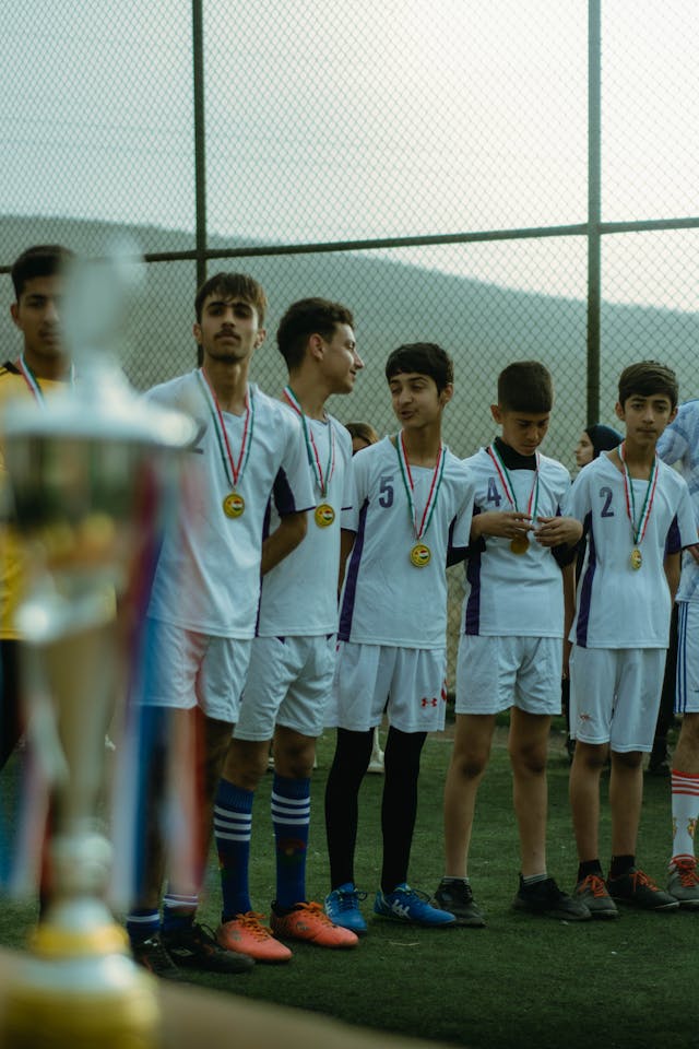 Young soccer players celebrating with medals after a tournament victory.