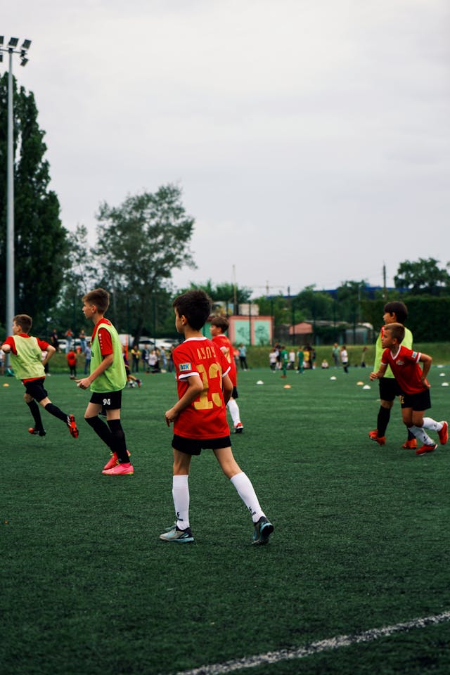 Kids training on a soccer field, improving teamwork and skills.