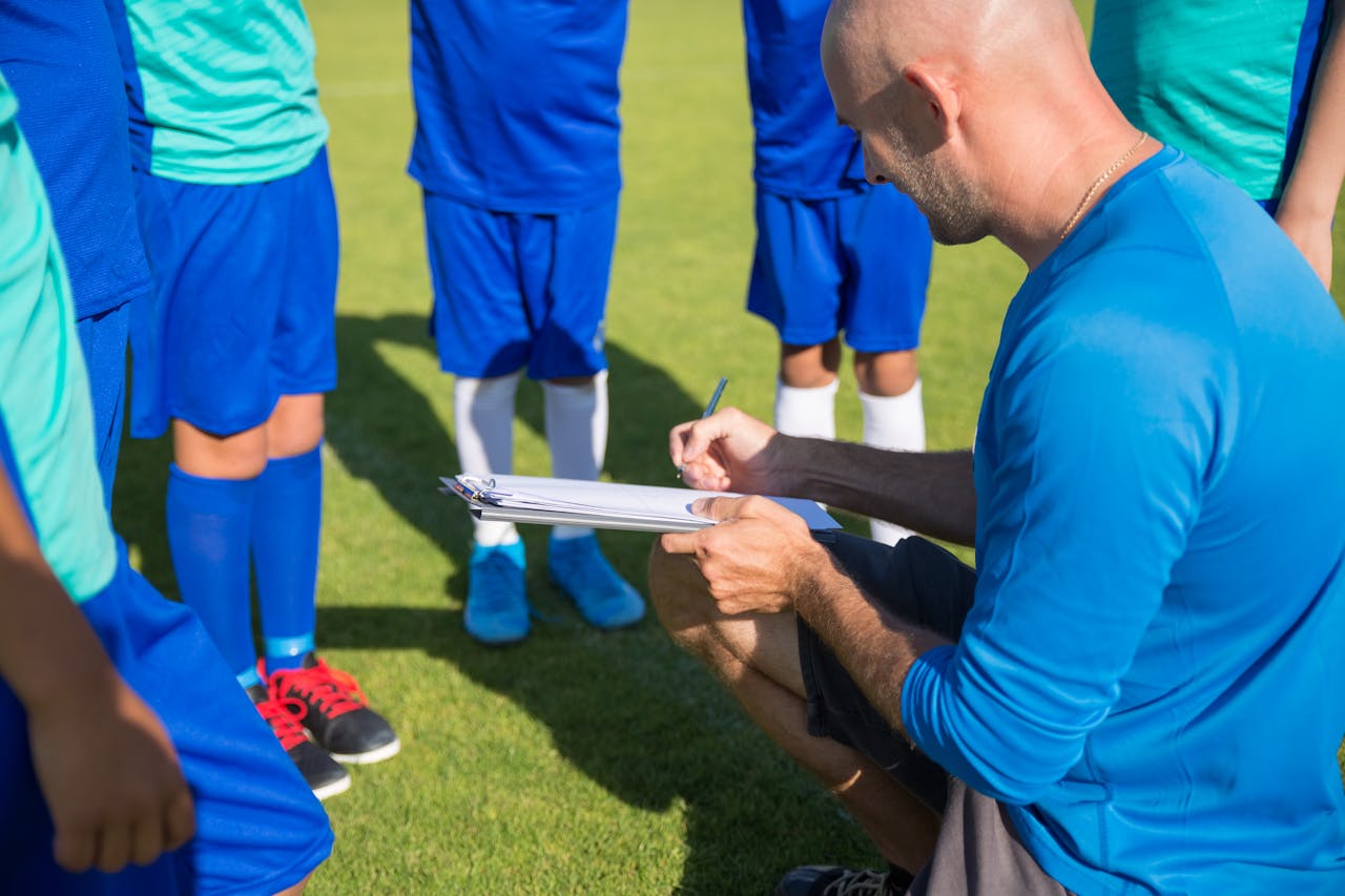 Soccer coach providing individualized tactical training to young athletes, focusing on strategy, teamwork, and skill development at Osner’s FC Academy.