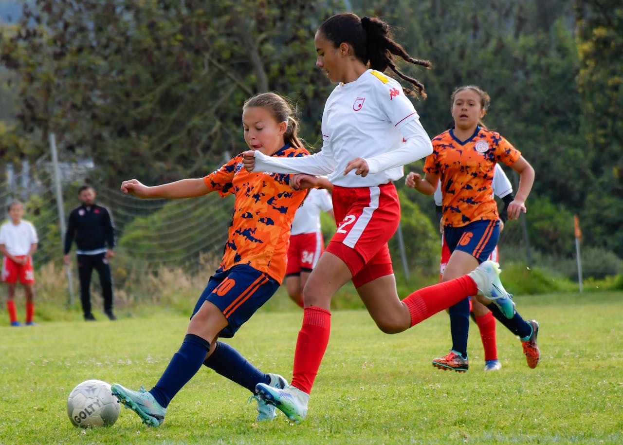 Diverse group of young soccer players competing in a match, showcasing Osner’s FC Academy’s commitment to inclusion and equal opportunities.