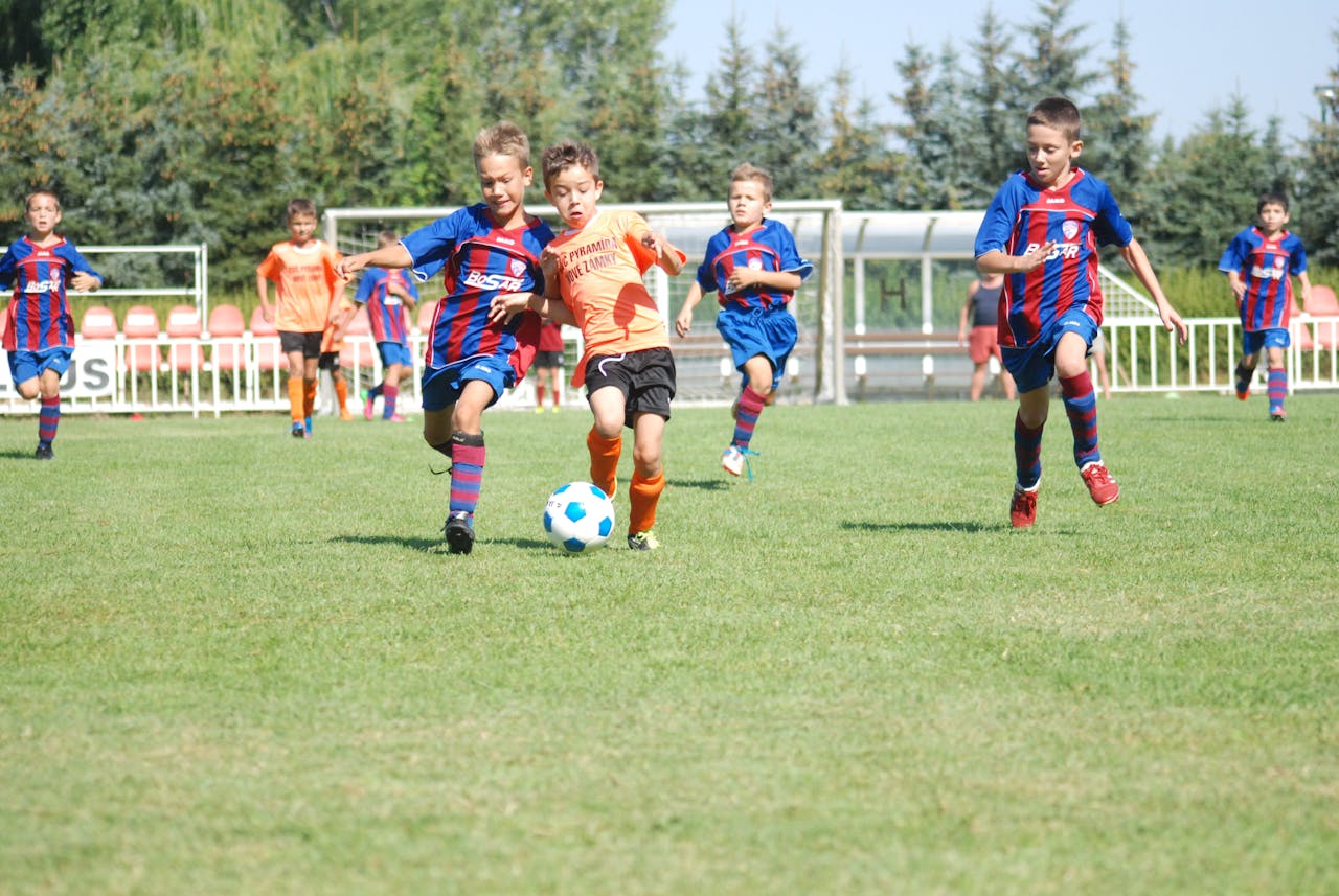 Excited young athletes playing soccer at a community tournament hosted by Osner’s FC Academy, fostering teamwork and sportsmanship.