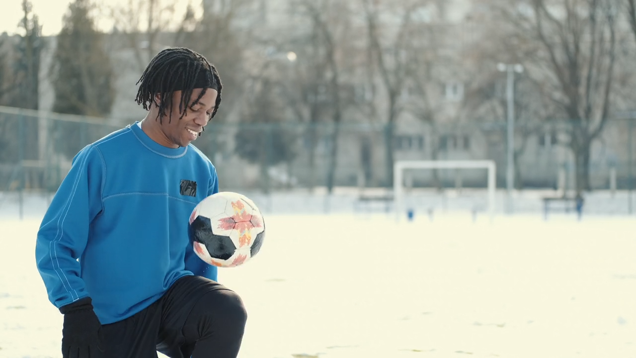 Young soccer player practicing ball control on a snowy field during Osner FC’s Winter Break Camp.