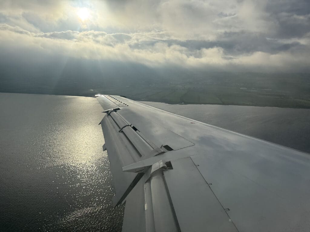 wing of an airplane flying over water
