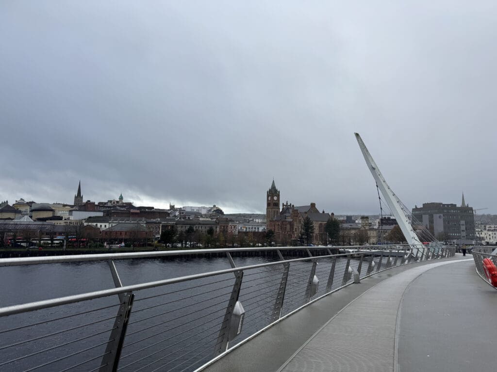 a bridge over water with a bridge and a city in the background