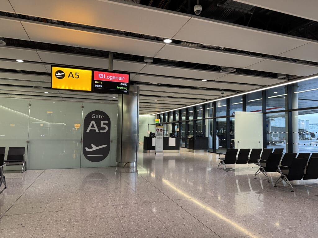 a large airport terminal with chairs and signs