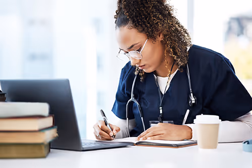 Physician working in front of laptop