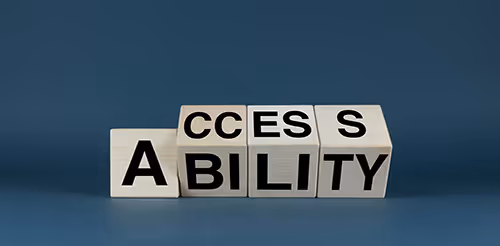 Wooden letter blocks arranged to spell ACCESSIBILITY on a blue background.