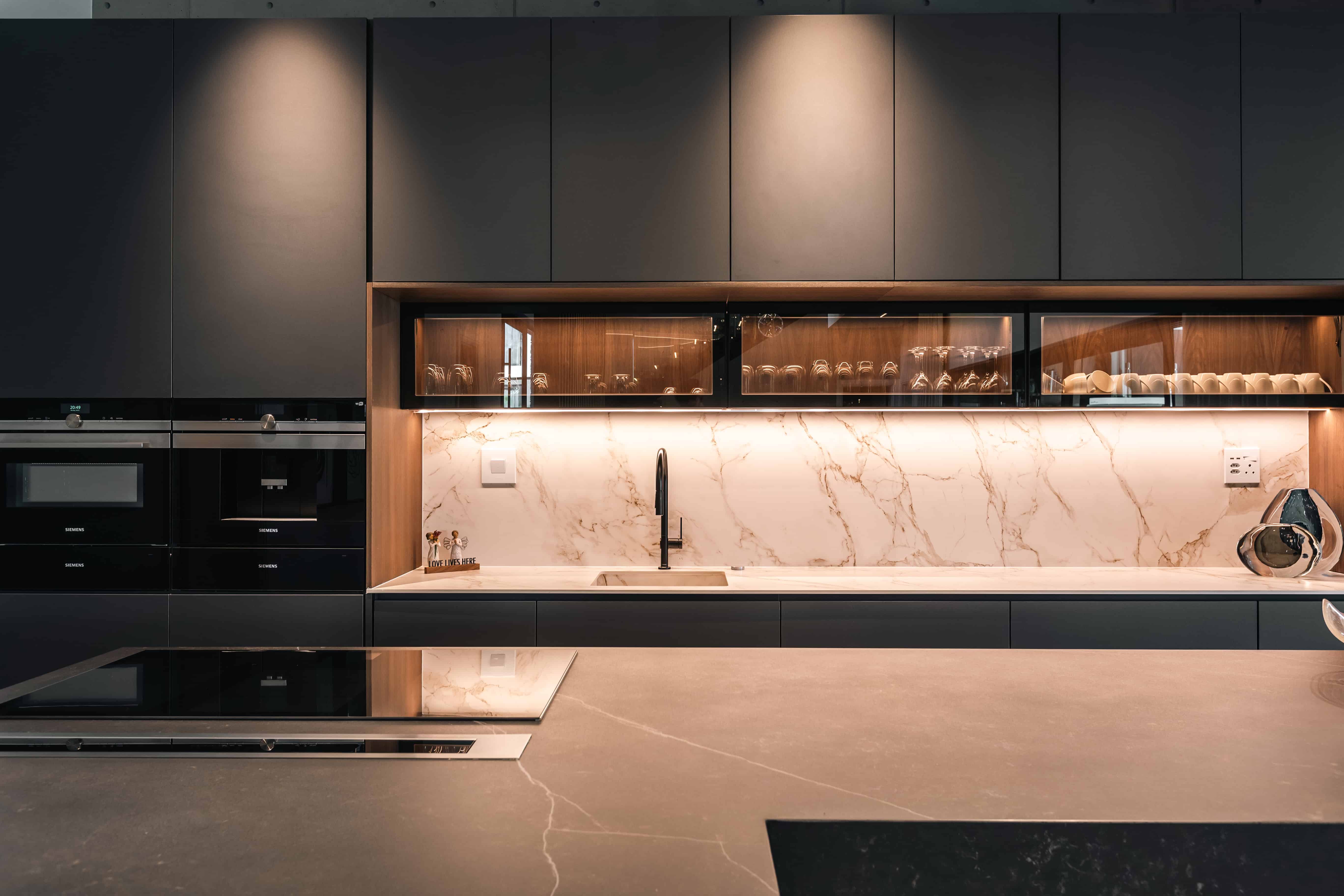 Contemporary kitchen with minimalist finishes and soft lighting in Steyn City home by Renovatio Interior Design.