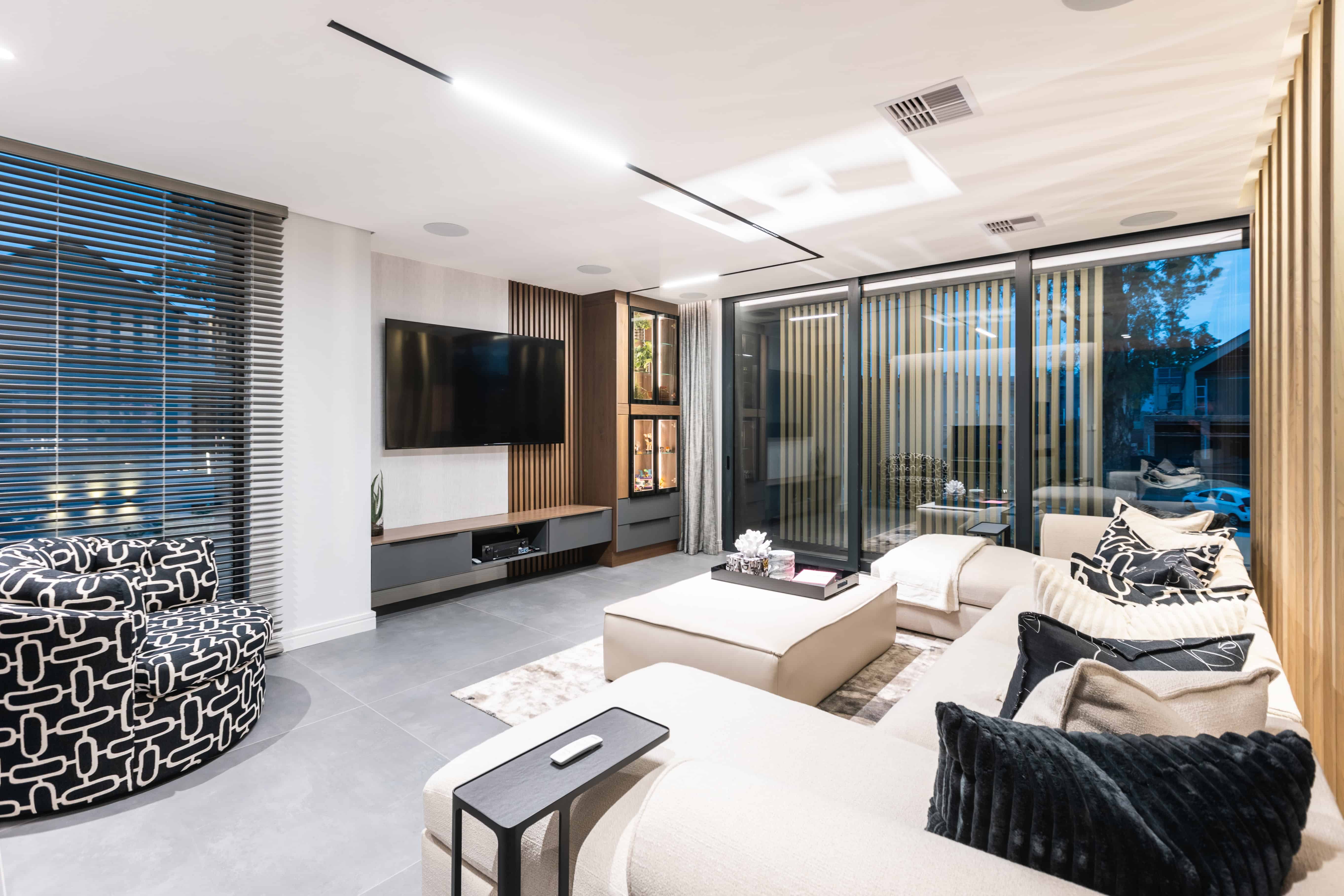 Bright modern pyjama lounge with twin sofas and large glazing, Steyn City – Renovatio Interiors Johannesburg.