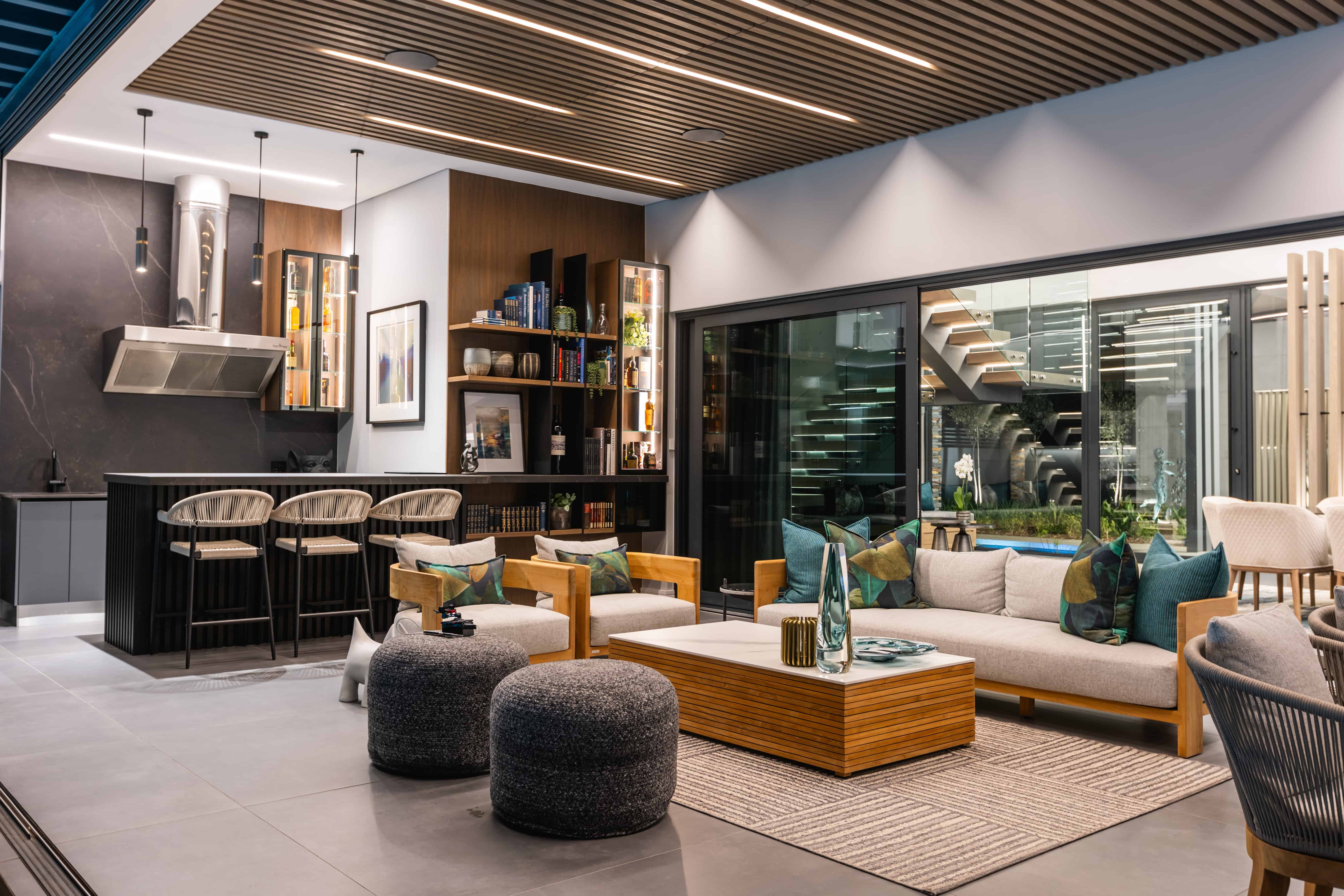 Luxury open-plan outdoor living space with glass façade connecting to patio, Steyn City residence – Renovatio Interiors Johannesburg.