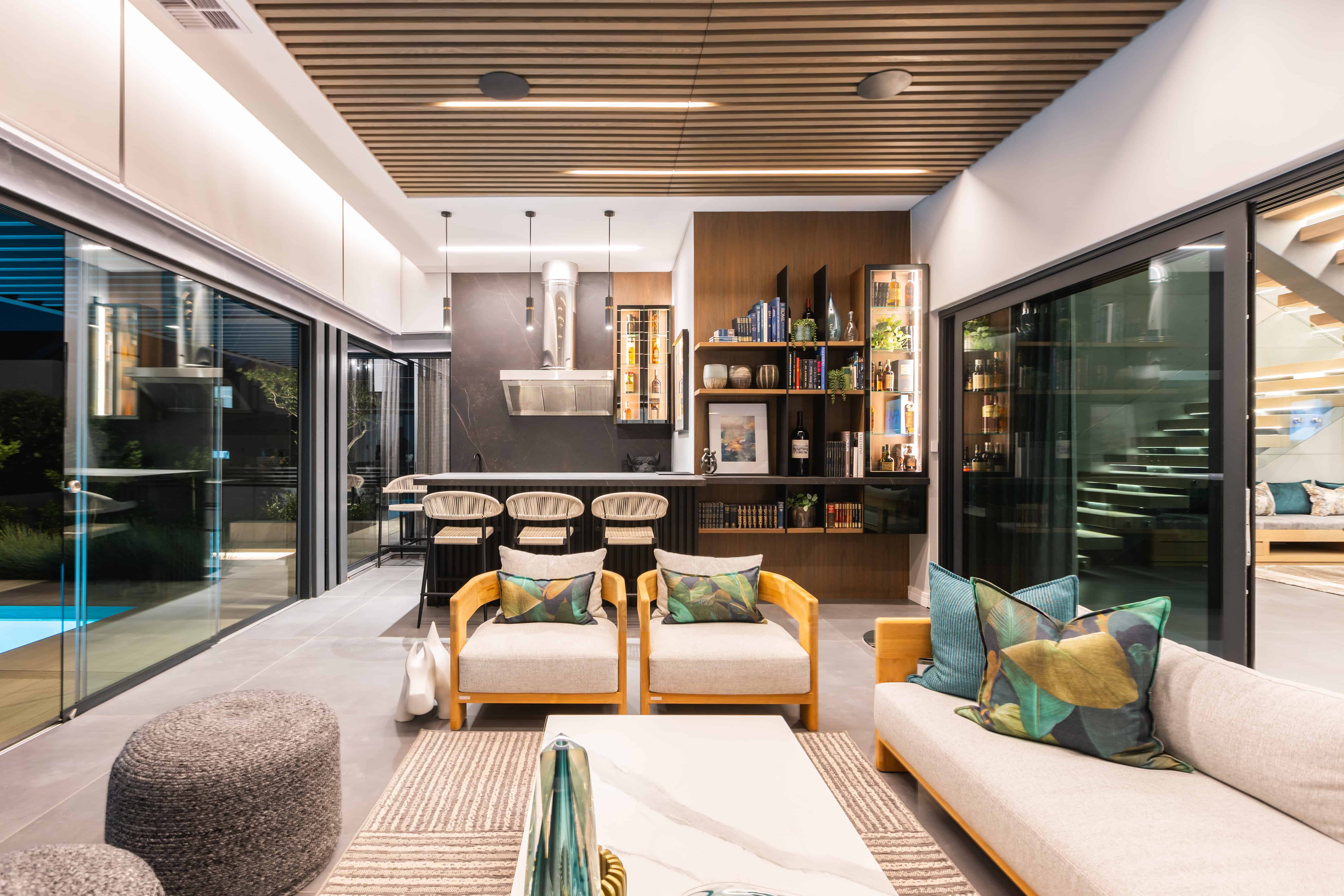 Indoor-outdoor lounge and dining area opening to pool terrace, Steyn City – Renovatio Interior Design Johannesburg.
